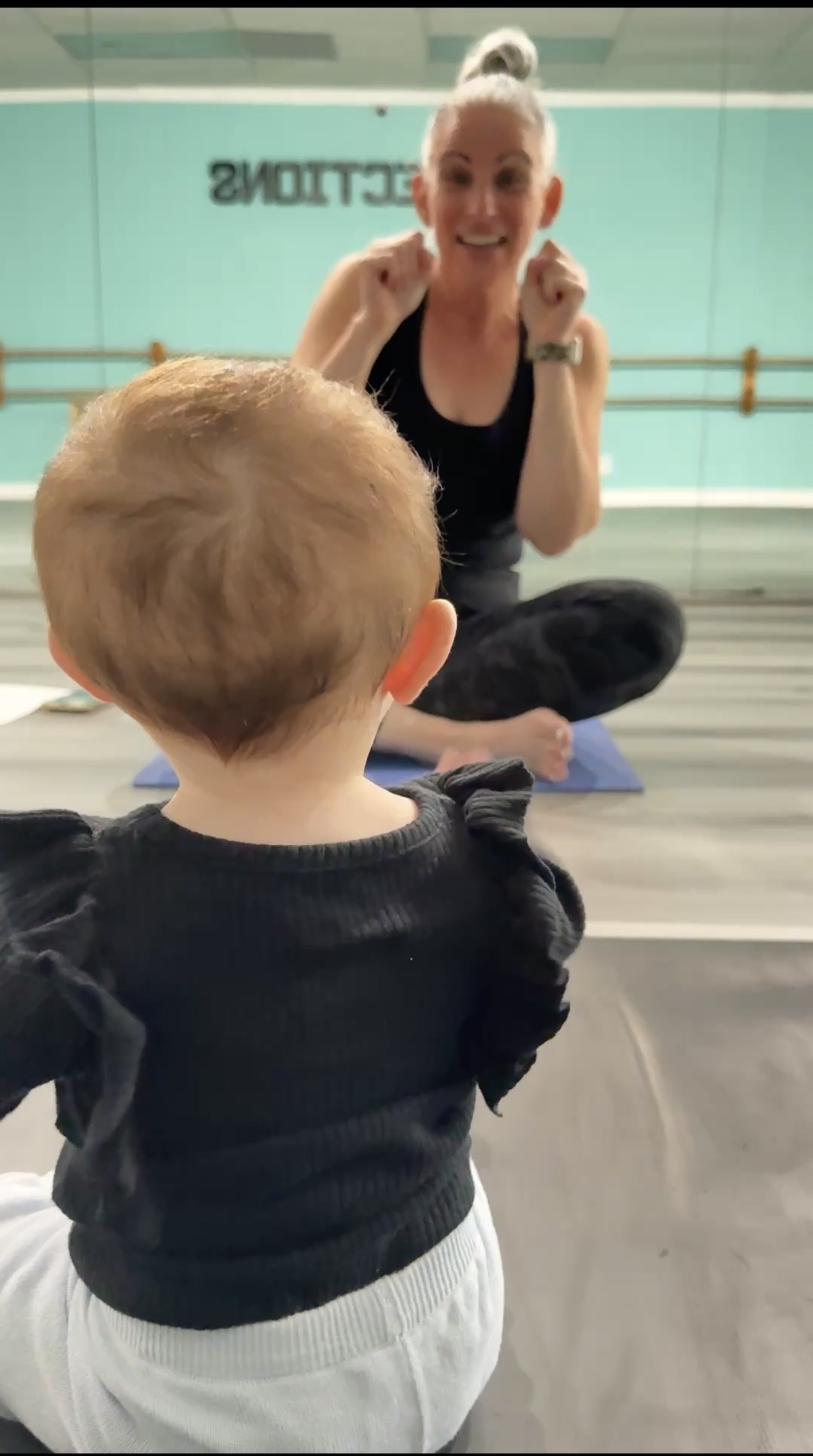 Ms. Karen smiling with a little dancer in the studio